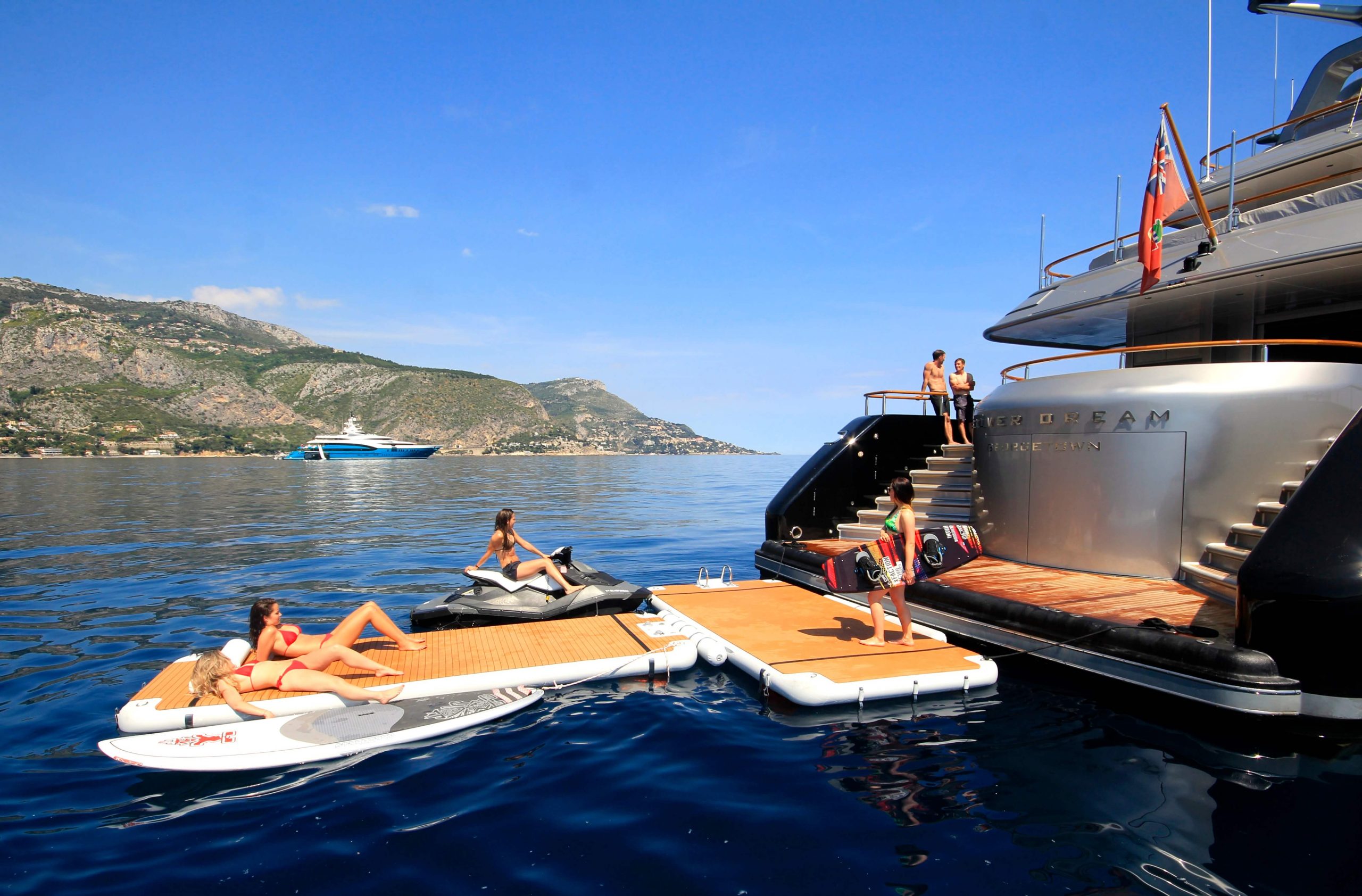 Holiday makers swimming and sunbathing on yacht