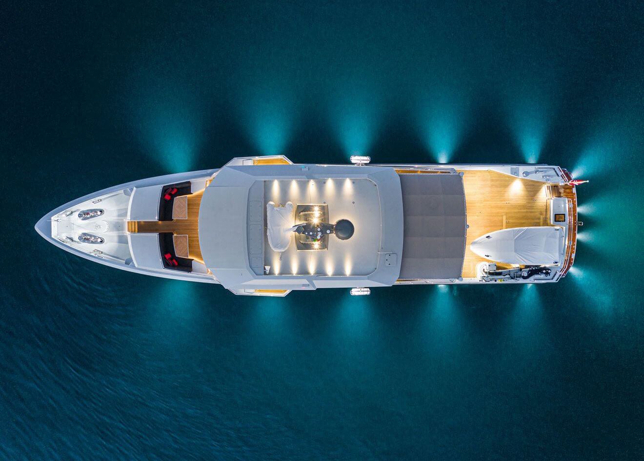 Evening arial shot of yacht in water with lighting
